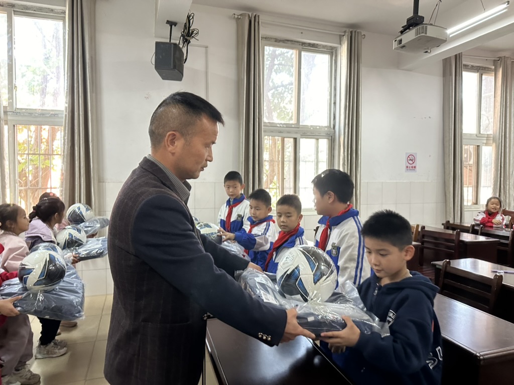 A student receiving donated soccer and activity supplies during the school visit.