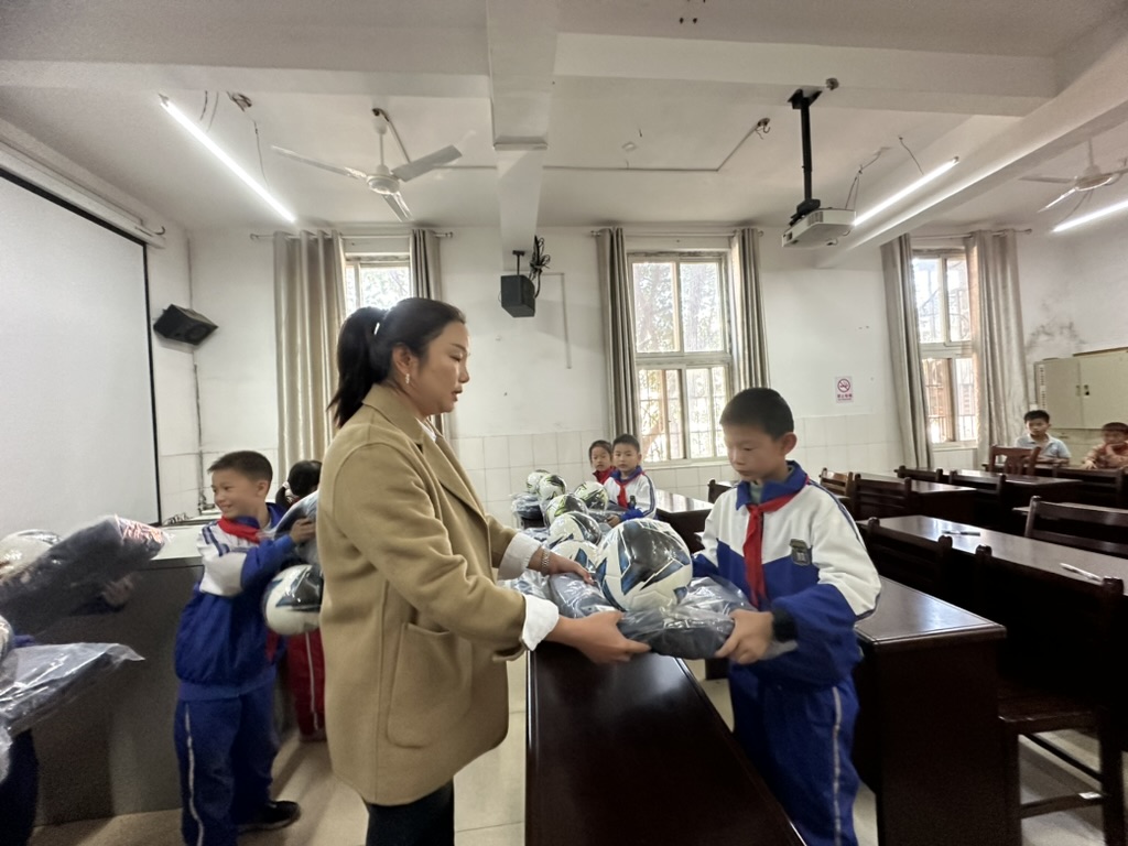 A foundation representative greeting a school representative at Jiujiang Ailian Primary School.